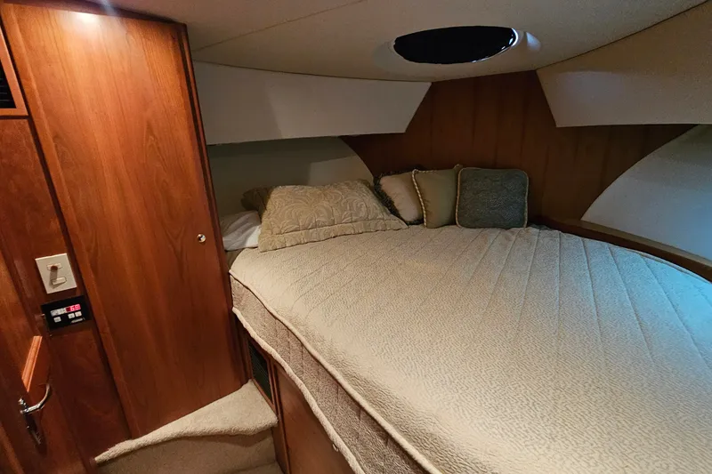 Slide: The Image of Cozy bedroom interior of 2003 Silverton 35 Motor Yacht with wood paneling and plush bedding. - 24