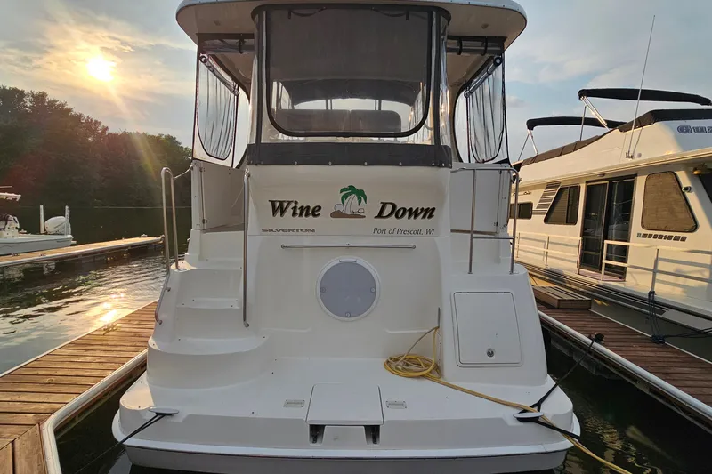 Slide: The Image of 2003 Silverton 35 Motor Yacht docked at sunset, featuring "Wine Down" name. - 5