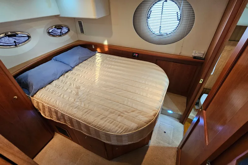 Slide: The Image of 2003 Silverton 35 Motor Yacht bedroom with cozy bed and porthole windows. - 28