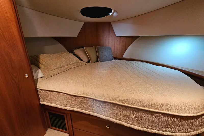 Slide: The Image of Cozy bedroom interior of 2003 Silverton 35 Motor Yacht with plush bedding. - 23