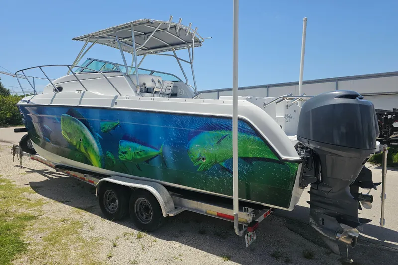 The Image of 2007 Glacier Bay 2670 Isle Runner boat with vibrant fish graphics on trailer. - 0