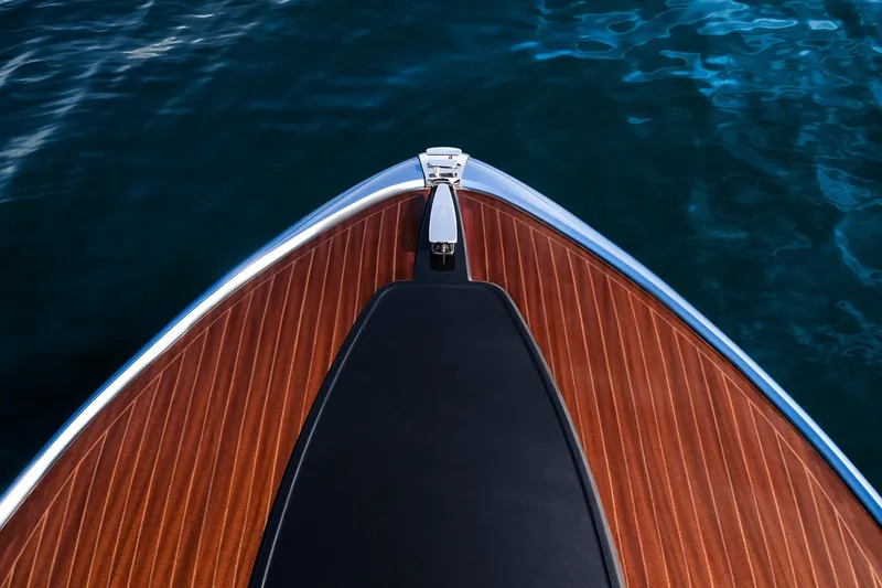 Slide: The Image of Bow of 2004 Riva El-Iseo boat with sleek wooden deck on water. - 3