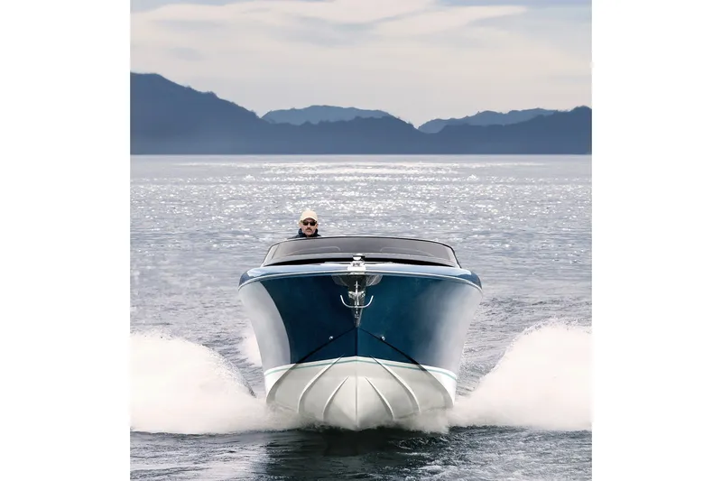 Slide: The Image of Front view of a 2004 Riva El-Iseo boat cruising on a serene lake. - 4