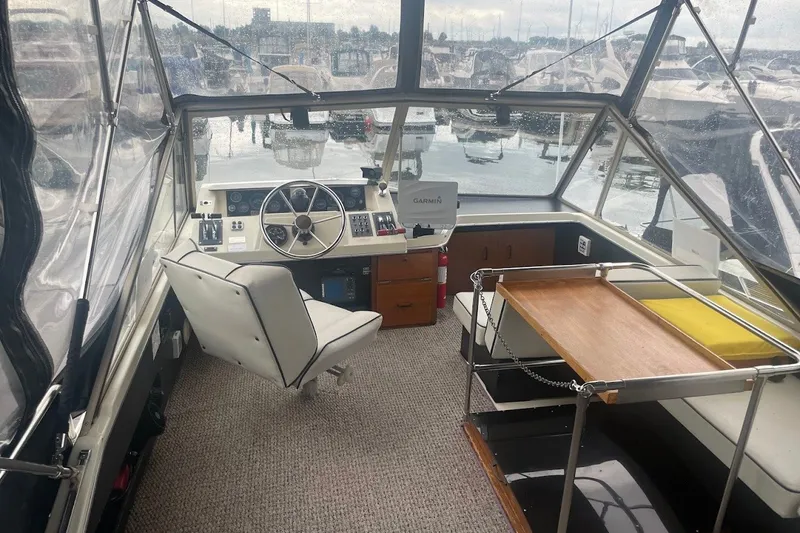 Slide: The Image of Interior of a 1980 Carver 33 Mariner boat with helm and seating area. - 7