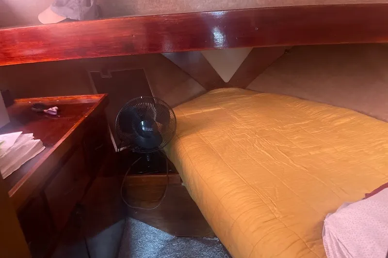Slide: The Image of Cozy cabin interior of 1980 Carver 33 Mariner with bed, fan, and wooden desk. - 4