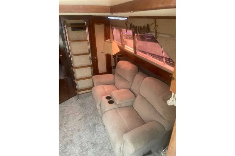 Slide: The Image of Interior of 1980 Carver 33 Mariner with beige recliner sofa and wooden ladder. - 8