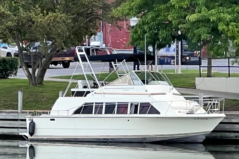 Slide: The Image of 1980 Carver 33 Mariner docked by a tree-lined waterfront. - 2