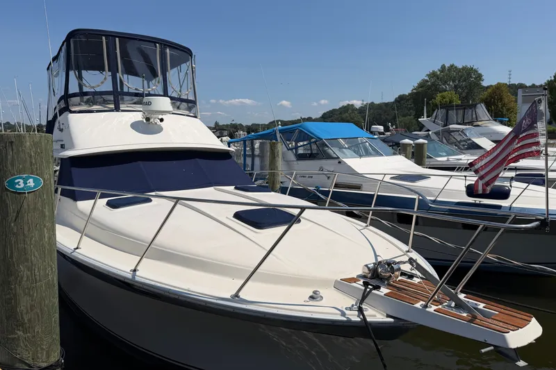 The Image of 1987 Silverton 34 Convertible yacht docked at marina with American flag. - 0