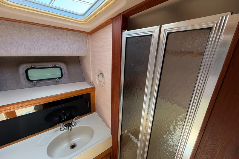 Slide: The Image of 1987 Silverton 34 Convertible bathroom with sink, mirror, and shower enclosure. - 34