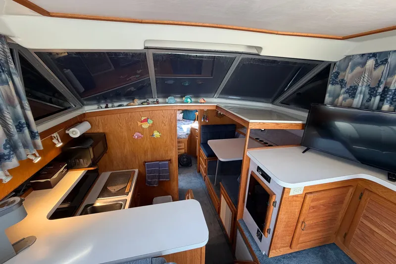 Slide: The Image of Interior of 1987 Silverton 34 Convertible boat with kitchen, seating, and TV. - 20