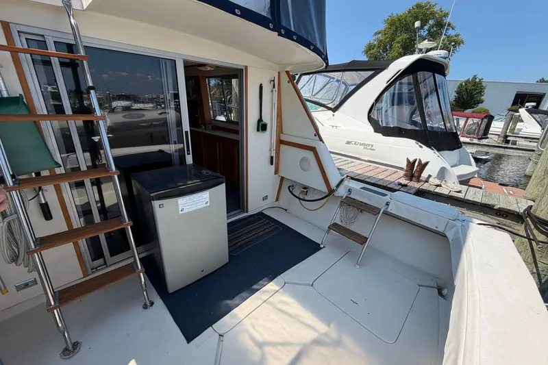 Slide: The Image of 1987 Silverton 34 Convertible yacht interior with ladder, fridge, and dock view. - 8