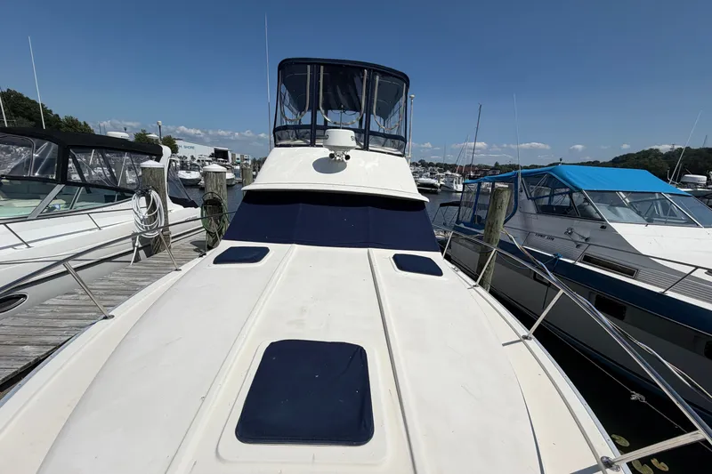 Slide: The Image of 1987 Silverton 34 Convertible yacht docked at marina under clear blue sky. - 4
