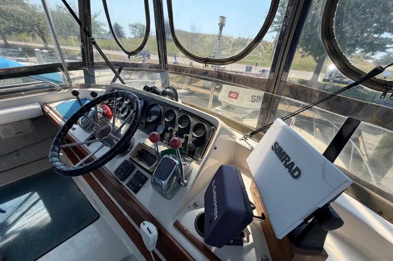 Slide: The Image of 1987 Silverton 34 Convertible boat cockpit with steering wheel and navigation equipment. - 12