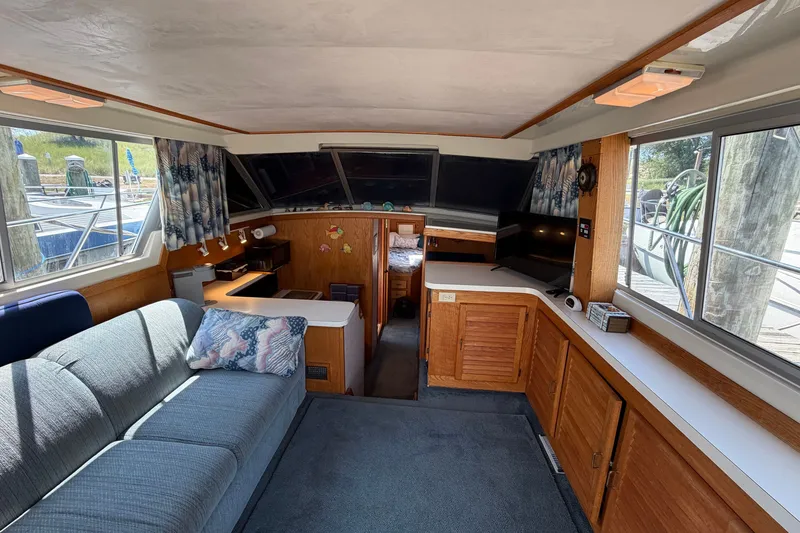 Slide: The Image of Interior of 1987 Silverton 34 Convertible boat with cozy seating and wooden cabinetry. - 17