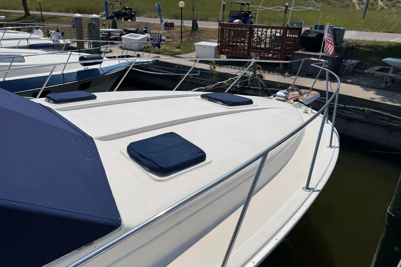 Slide: The Image of 1987 Silverton 34 Convertible boat docked, featuring a spacious deck with blue covers. - 3