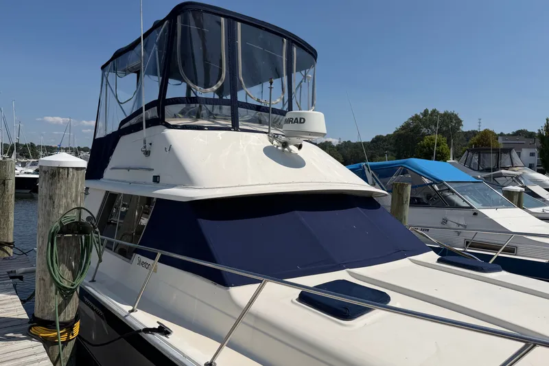 Slide: The Image of 1987 Silverton 34 Convertible boat docked at marina under clear blue sky. - 1