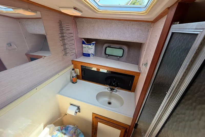 Slide: The Image of 1987 Silverton 34 Convertible boat bathroom with sink, mirror, and skylight. - 32