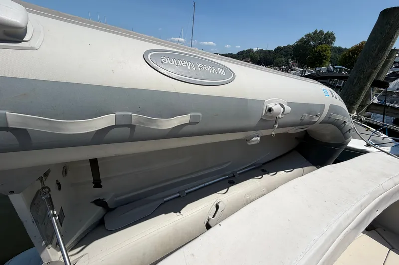 Slide: The Image of Inflatable boat on 1987 Silverton 34 Convertible yacht, docked at marina under clear sky. - 40