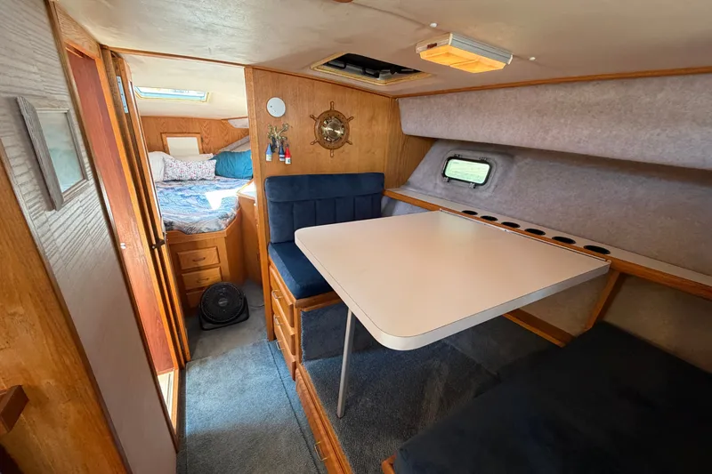 Slide: The Image of Interior of a 1987 Silverton 34 Convertible boat with dining area and cozy sleeping quarters. - 21