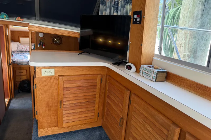 Slide: The Image of Interior of 1987 Silverton 34 Convertible with wooden cabinetry and a mounted TV. - 19