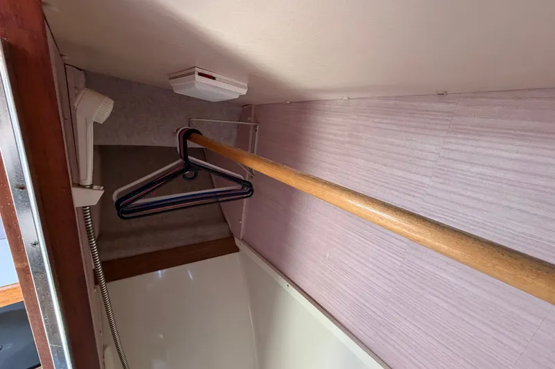 Slide: The Image of Interior closet of 1987 Silverton 34 Convertible boat with hangers and wooden rod. - 35