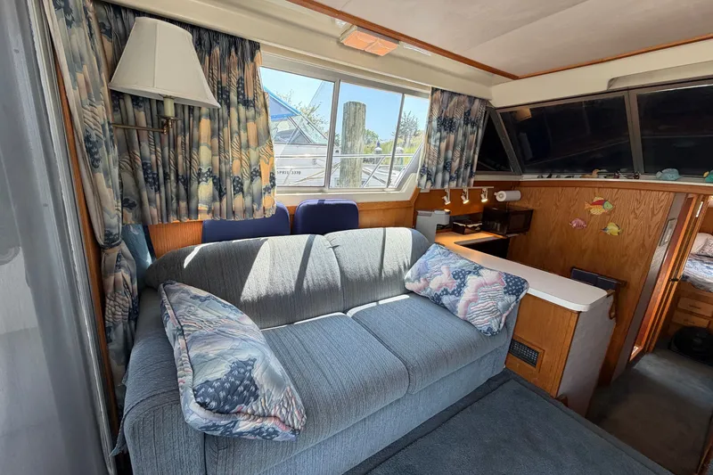 Slide: The Image of Interior of a 1987 Silverton 34 Convertible boat with cozy seating and nautical decor. - 18
