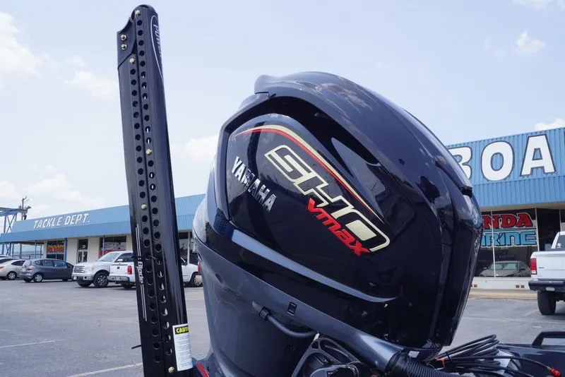 Slide: The Image of Outboard motor on a 2027 Phoenix 921 Elite X boat, parked near a marine store. - 9
