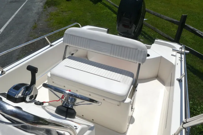 Slide: The Image of 2011 Boston Whaler 150 Montauk boat interior with steering wheel and seating. - 5