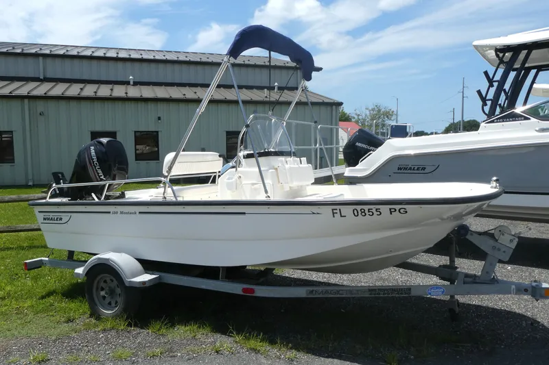 The Image of 2011 Boston Whaler 150 Montauk boat on trailer, parked outdoors. - 0