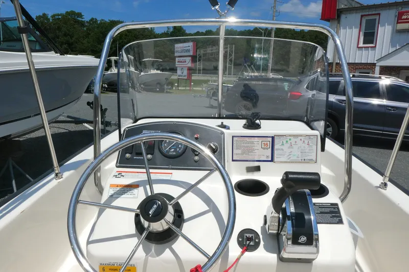Slide: The Image of 2011 Boston Whaler 150 Montauk boat dashboard with steering wheel and controls. - 6