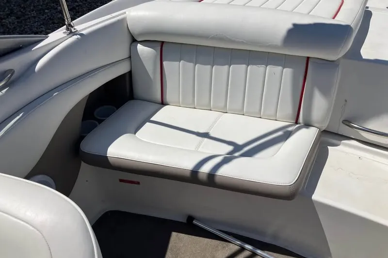 Slide: The Image of White leather seating on a 2003 Cobalt 220 boat, featuring red accents and cup holders. - 18