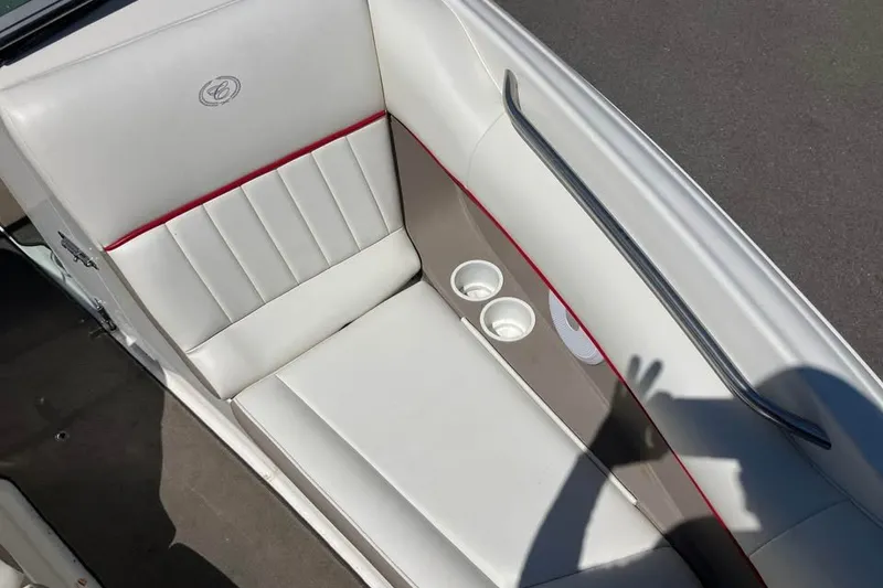 Slide: The Image of White leather seating in a 2003 Cobalt 220 boat with cup holders and red accents. - 9