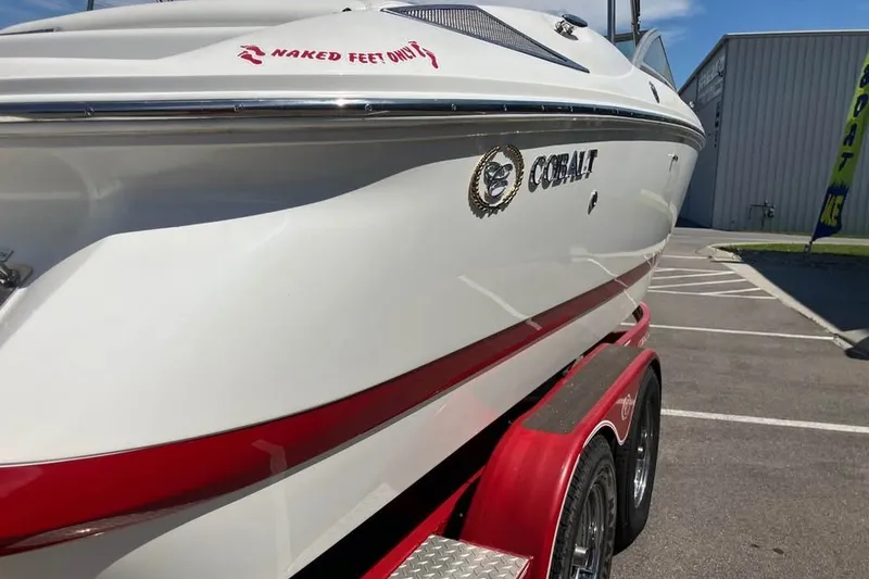 Slide: The Image of 2003 Cobalt 220 boat on red trailer, parked outdoors. - 6