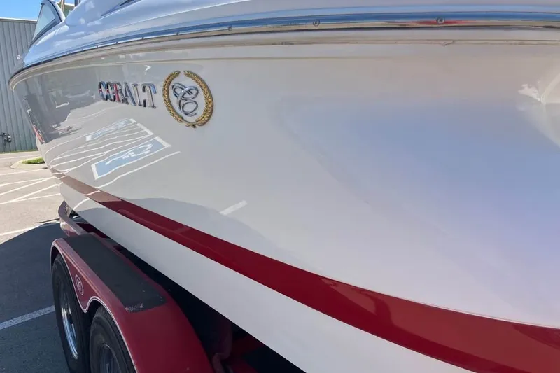 Slide: The Image of 2003 Cobalt 220 boat with red stripe on trailer in parking lot. - 3