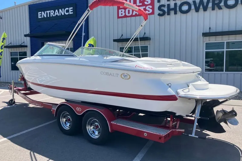 Slide: The Image of 2003 Cobalt 220 boat on a trailer outside a showroom. - 2