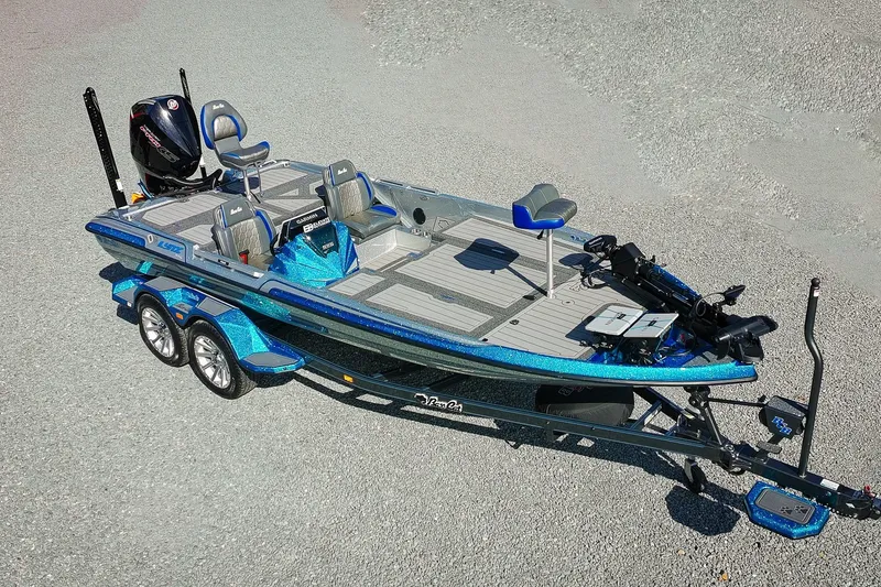 Slide: The Image of 2026 Bass Cat Lynx STS fishing boat with dual seats and trailer on gravel surface. - 29