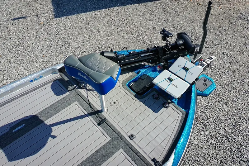 Slide: The Image of 2026 Bass Cat Lynx STS boat deck with Garmin electronics and seating on gravel surface. - 28