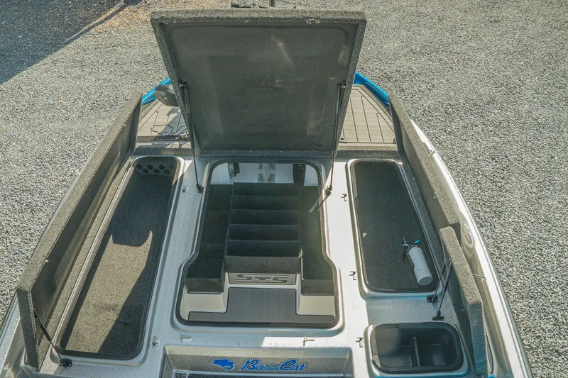 Slide: The Image of 2026 Bass Cat Lynx STS boat storage compartments with open lid, showcasing organized interior layout. - 17