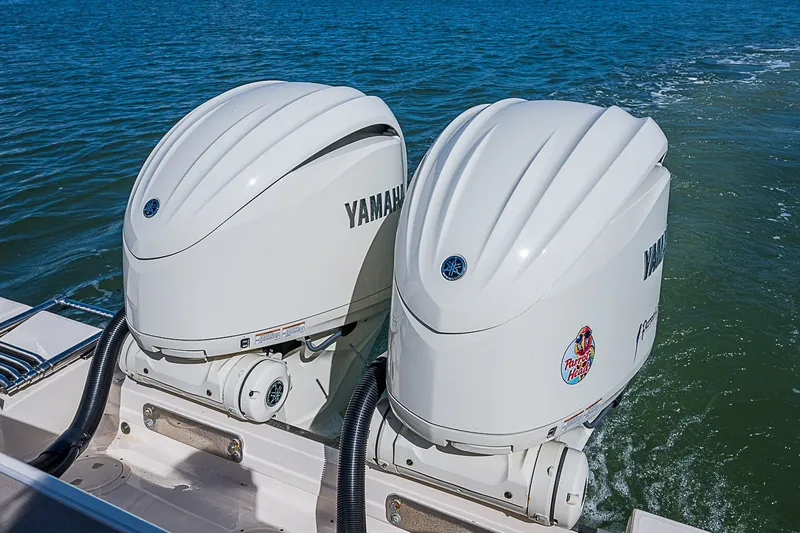 Slide: The Image of Twin Yamaha outboard engines on a 2024 Grady-White Freedom 307 boat in open water. - 16
