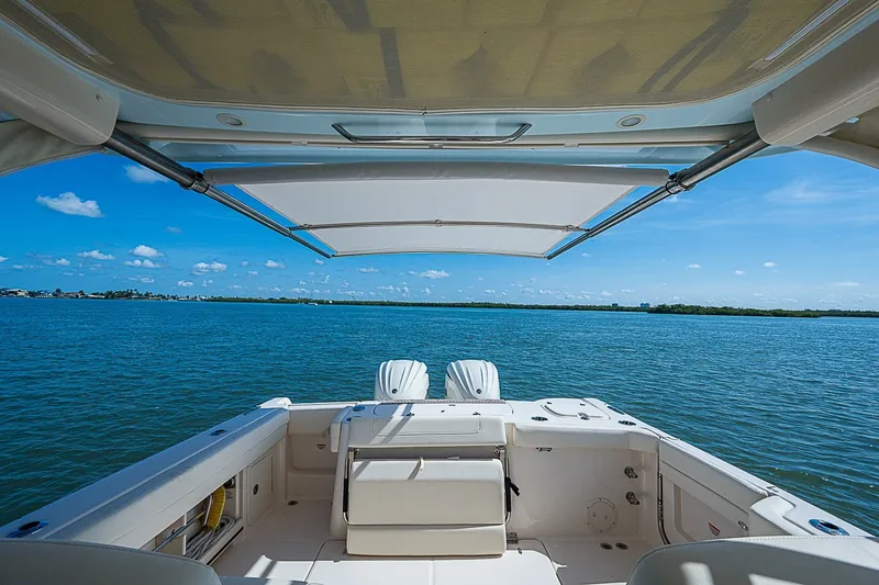 Slide: The Image of 2024 Grady-White Freedom 307 boat on open water, featuring spacious deck and canopy. - 21