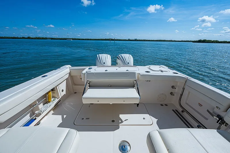 Slide: The Image of 2024 Grady-White Freedom 307 boat deck with seating, overlooking calm blue waters. - 20