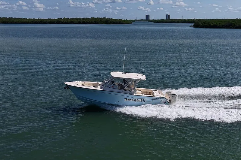 Slide: The Image of 2024 Grady-White Freedom 307 cruising on open water under a clear sky. - 50