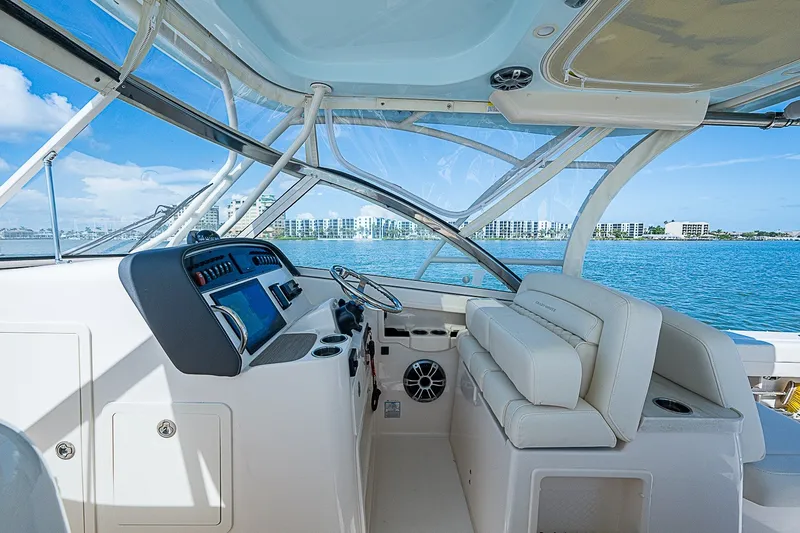 Slide: The Image of 2024 Grady-White Freedom 307 boat interior with modern dashboard and seating, overlooking calm waters. - 28