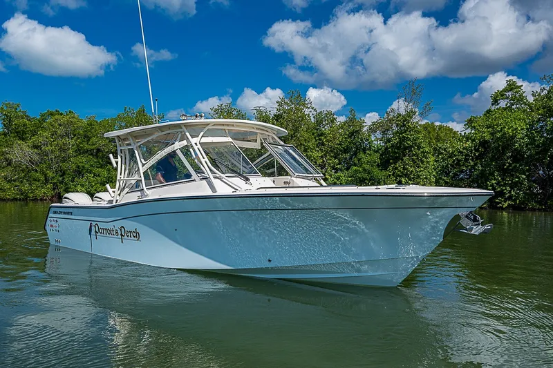 The Image of 2024 Grady-White Freedom 307 boat on calm water, surrounded by lush greenery. - 0