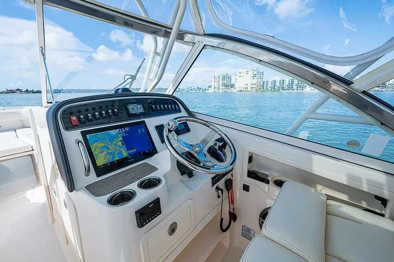 Slide: The Image of 2024 Grady-White Freedom 307 boat cockpit with steering wheel and navigation display. - 30
