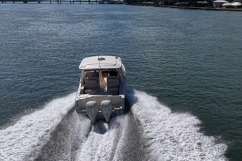 Slide: The Image of 2024 Grady-White Freedom 307 boat cruising on open water, rear view. - 47