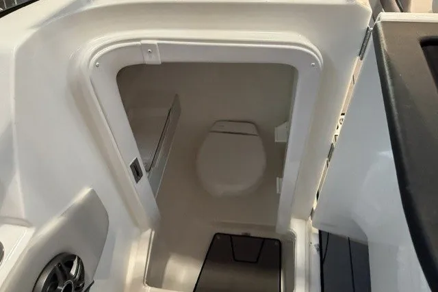Slide: The Image of 2026 Hurricane SunDeck 2600 OB boat interior with compact marine toilet. - 18
