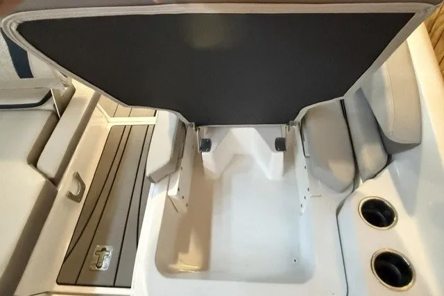 Slide: The Image of 2026 Hurricane SunDeck 2600 OB boat interior with storage compartment and cup holders. - 17
