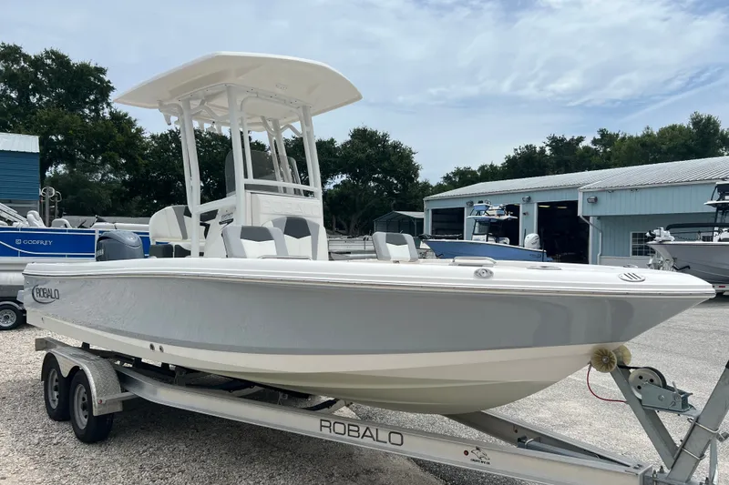 Slide: The Image of 2024 Robalo 226 Cayman boat on trailer, parked outdoors near storage facility. - 6