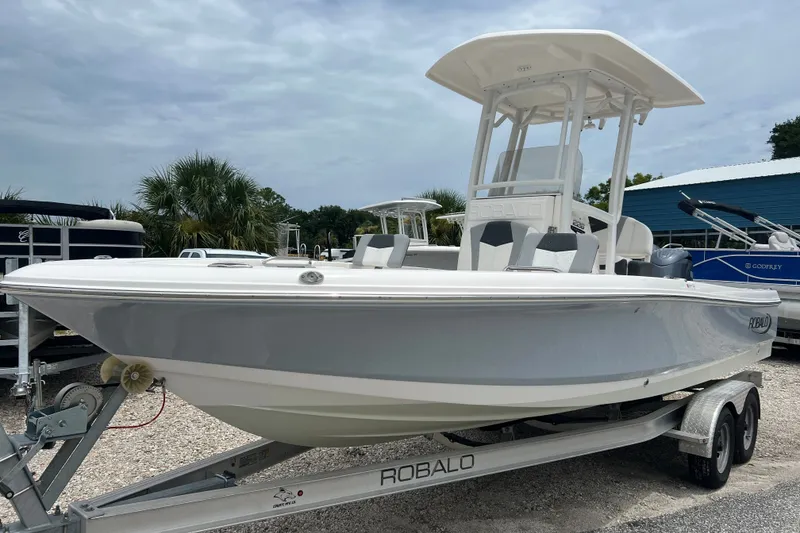 Slide: The Image of 2024 Robalo 226 Cayman boat on trailer, displayed outdoors under cloudy sky. - 8